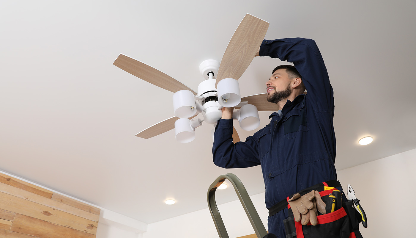 maintenance man repairing ceiling fan