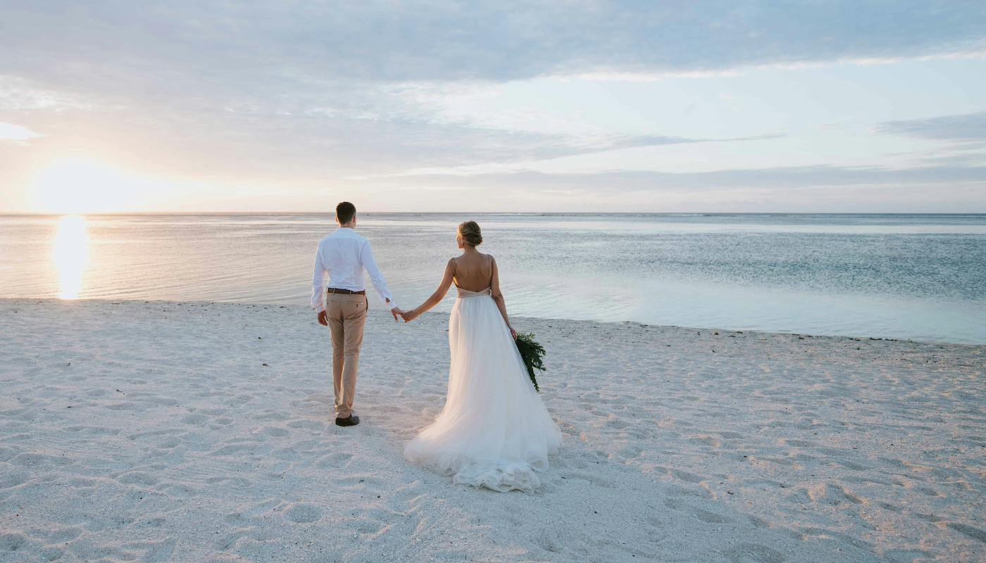 bride and groom walking on the beach