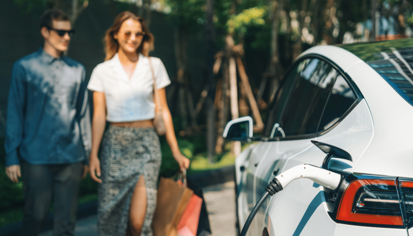 couple walking towards their car and ev charging station