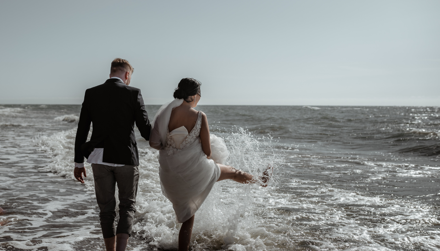 bride and groom walking on the beach
